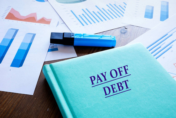 Finanční koncept znamenající PAY OFF DEBT s nápisem na notepadu. - Fotografie, Obrázek