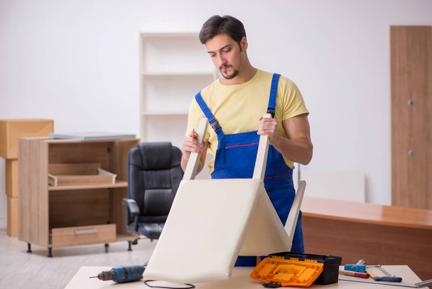 Young male carpenter repairing chair in the office - Photo, Image