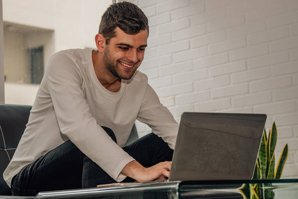 fiatal szakállas férfi dolgozik laptop otthon - Fotó, kép
