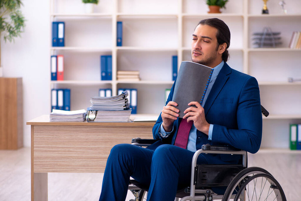 Młody niepełnosprawny pracownik pracujący w biurze - Zdjęcie, obraz