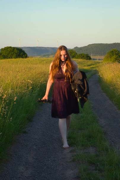 Adolescente marchant pieds nus sur une route de campagne en Allemagne rurale par une nuit de printemps. - Photo, image
