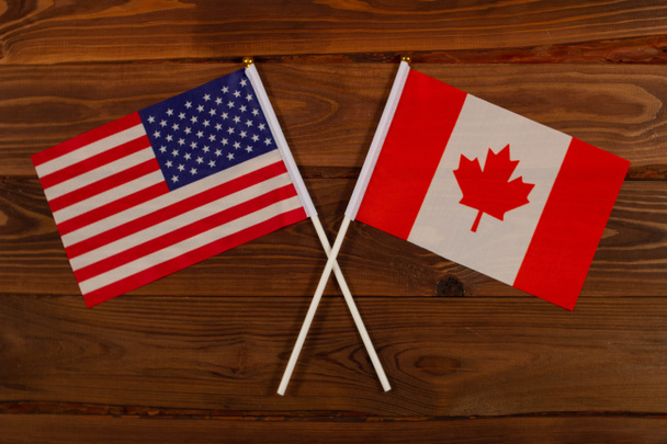 アメリカの国旗とカナダの国旗が交差した。アメリカ対カナダ。この画像は国間の関係を示しています。インターネットやメディアでのテレビや記事のビデオニュースのための写真. - 写真・画像