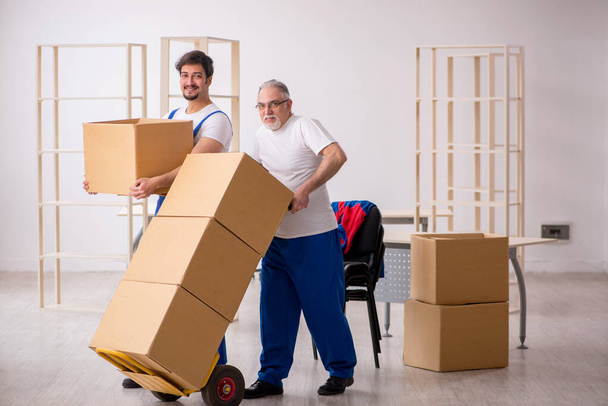 Dos hombres mudantes profesionales haciendo la reubicación del hogar - Foto, Imagen