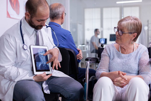 Vue de face du médecin discutant avec une femme âgée handicapée - Photo, image