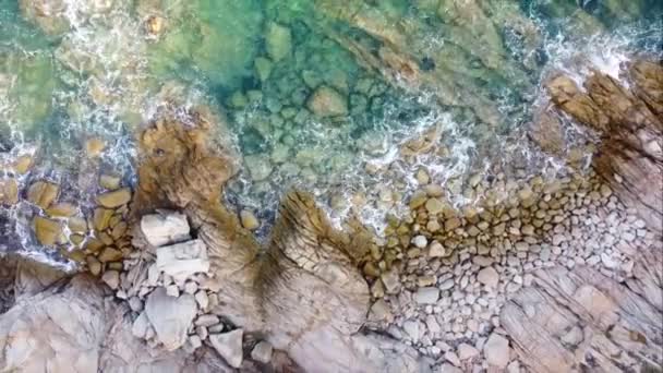Okyanus dalgalarının hava manzarası, İtalya 'nın kuzeyindeki Santa Teresa Gallura' nın en güzel sahil noktalarından birini süsleyen kayalık kıyı şeridini vuruyor. - Video, Çekim