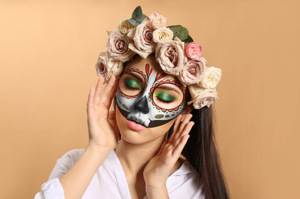 Jonge vrouw met geschilderde schedel op haar gezicht voor Mexico 's Dag van de Doden tegen kleur achtergrond - Foto, afbeelding