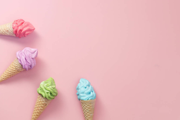 Verschiedene bunte Baiser-Eistüten auf rosa Hintergrund für süßes und erfrischendes Dessert-Konzept - Foto, Bild