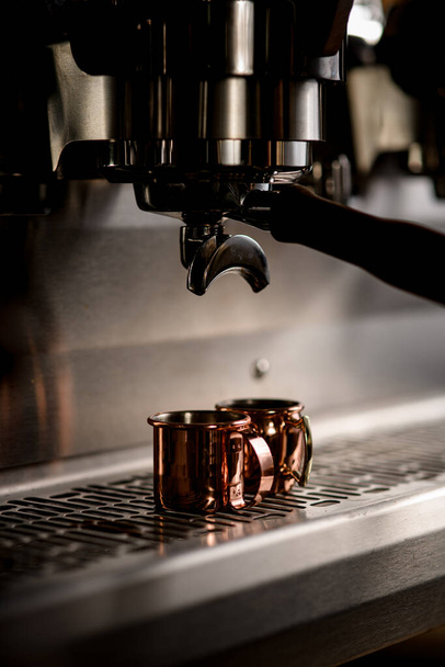 view of cups in espresso machine which making coffee and pouring it - 写真・画像