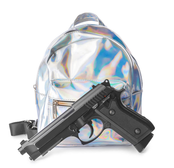 Pistola e mochila em fundo branco. Conceito de tiroteio escolar - Foto, Imagem