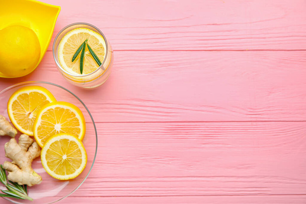Glass of healthy lemonade and squeezer on color wooden background - Photo, Image