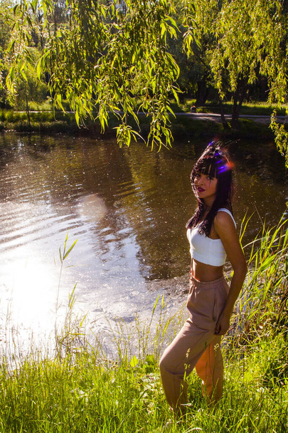 Beautiful young woman near the lake on the sunrise time - 写真・画像