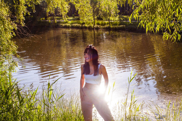 Beautiful young woman near the lake on the sunrise time - Photo, Image