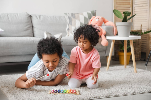 Afro-Amerikaanse kinderen spelen thuis met xylofoon - Foto, afbeelding