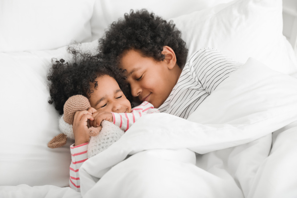 Afroamerykańskie dzieci leżące w łóżku - Zdjęcie, obraz