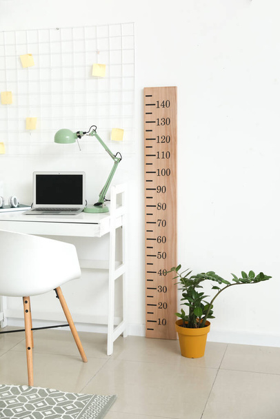 Modern workplace with stadiometer near light wall - Photo, Image
