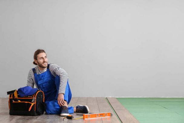 Carpenter during installing of laminate flooring in room - Photo, Image