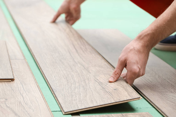Carpenter installing laminate flooring in room, closeup - Photo, Image