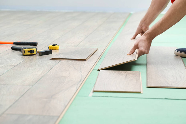 Carpenter installing laminate flooring in room - Φωτογραφία, εικόνα