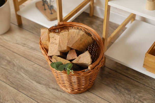 Basket with firewood on floor in room - Photo, Image