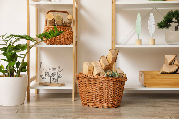 Baskets with firewood near light wall in room - Photo, Image