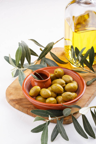Crushed green olives in bowl on white table. Close-up. - Fotografie, Obrázek