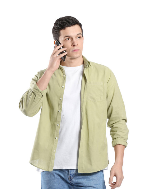 Fiatal férfi beszél mobiltelefon fehér háttér - Fotó, kép