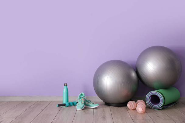 Set sportartikelen met fitnessballen in de buurt van kleurenwand - Foto, afbeelding