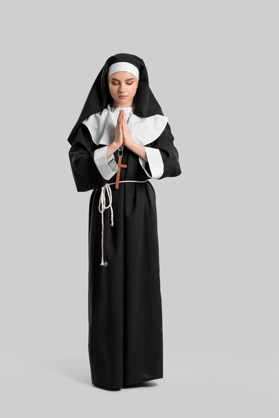 Junge betende Nonne auf hellem Hintergrund - Foto, Bild