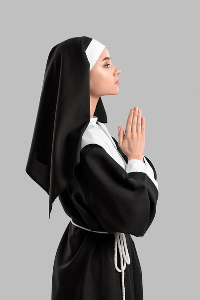 Jeune religieuse priante sur fond de lumière - Photo, image