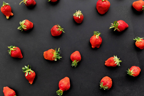 Ripe strawberries on black background, summer berry, top view - Photo, Image