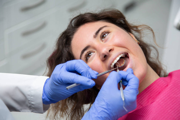 Egy lány száján dolgozó fogorvos közelsége. - Fotó, kép
