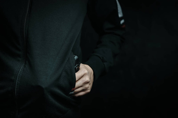 Il menace avec une arme dans la poche de sa veste. - Photo, image