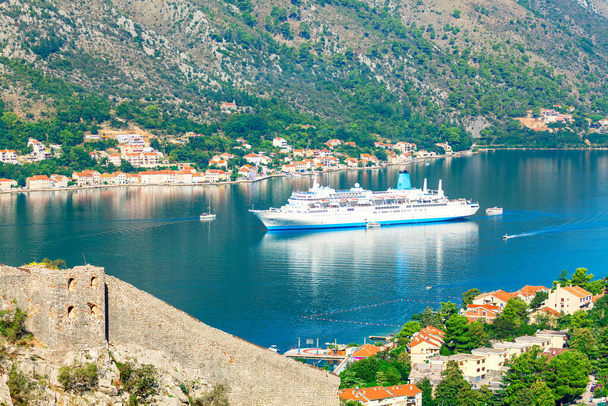 Statek wycieczkowy w Kotor Bay Czarnogóra. Spektakularny widok na duży statek w lagunie. Stare miasto Kotor. Zamek San Giovanni - Zdjęcie, obraz