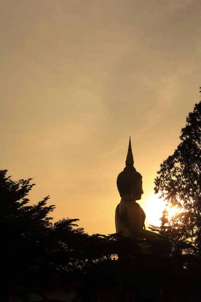 Zachód słońca, wielki posąg Buddy w świątyni - Zdjęcie, obraz