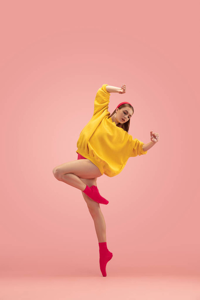 Flexible joven hermosa chica, entrenamiento de bailarina de ballet femenino aislado sobre fondo rosa. - Foto, imagen