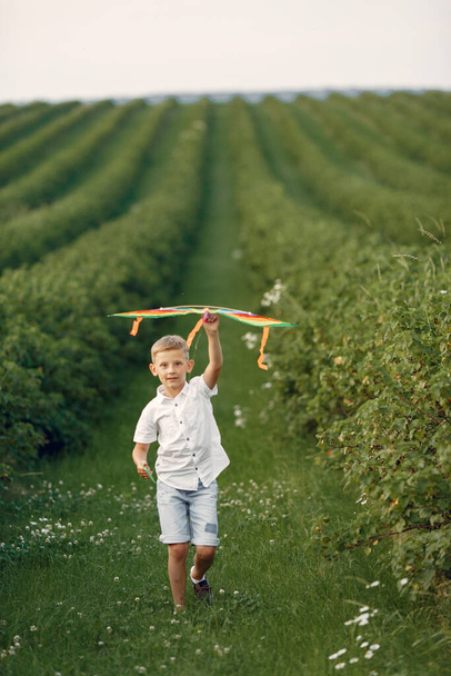 Excited little boy running with a toy plane - Foto, afbeelding