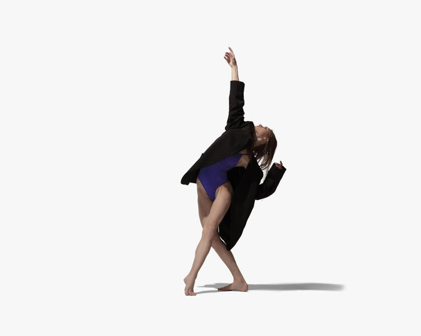 Solo. Junge schöne Mädchen, Balletttänzerin tanzt isoliert über weißem Hintergrund mit Schatten. - Foto, Bild
