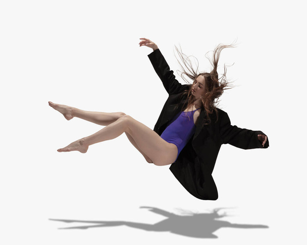 Flying. Young beautiful girl, female ballet dancer dancing isolated over white background with shadow. - Valokuva, kuva