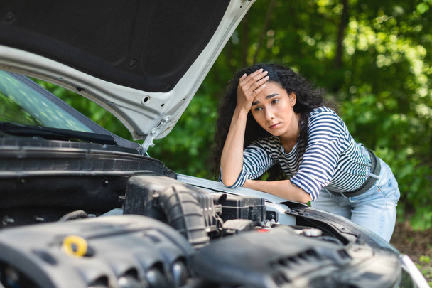 Sad brunette woman leaning on car hood, waiting for service - Photo, Image