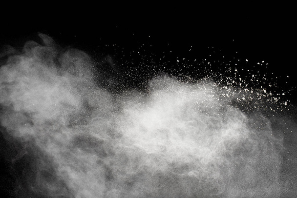 Άσπρο σύννεφο έκρηξης σκόνης ενάντια στο μαύρο φόντο.Λευκά σωματίδια σκόνης πιτσιλίζουν. - Φωτογραφία, εικόνα