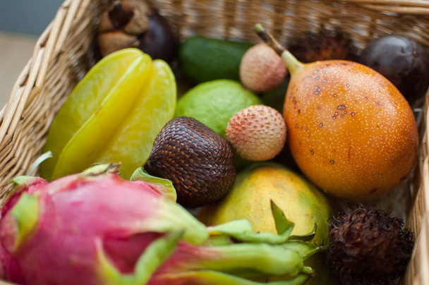 Большая корзина свежих тропических фруктов, маракуйя, карамбола, драконьи фрукты или питайя, мангостин, личи, гранадилья. Экзотические фрукты, концепция здорового питания - Фото, изображение