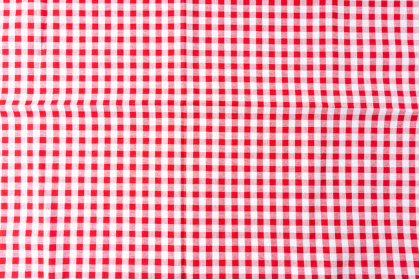 Zgnieciony obrus jadalny z białym i czerwonym wzorem warcaby jest tłem. Widok z góry dla projektu menu żywności. Używane do przykrywania stołu, aby zapobiec plamom, ułatwiają czyszczenie stołu. - Zdjęcie, obraz