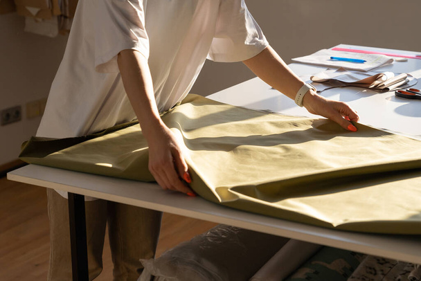 Lähikuva naisten viemäri pidä kangasta leikata työskentelevät työpaja studio. Luova prosessi ateljeessa - Valokuva, kuva