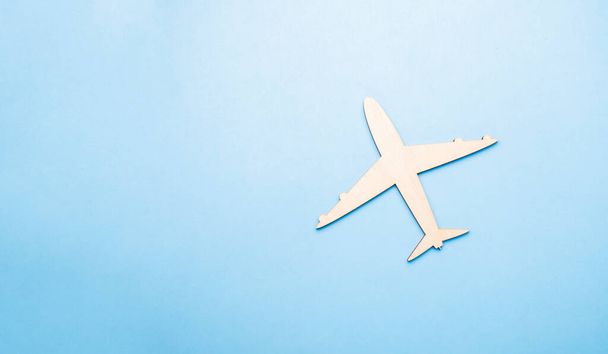 Model of a toy airplane of white color on a blue background with place for adding text, concept of air transportation, tourism, travel. - Photo, image