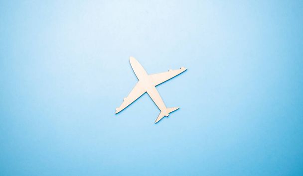Modèle d'un avion jouet de couleur blanche sur un fond bleu avec place pour ajouter du texte, concept de transport aérien, tourisme, voyage. - Photo, image
