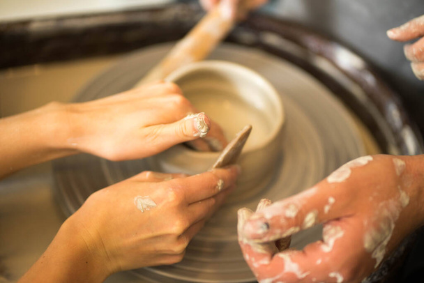 human hands make a clay product on a potters wheel - Fotó, kép