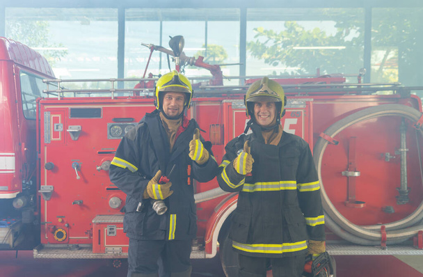 Retrato de un grupo de bomberos caucásicos o equipo de bomberos con uniforme, trabajando en su carrera. Un rescate por accidente de emergencia. Gente. Trabajo en equipo con un camión de bomberos. Trabajo de servicio - Foto, imagen