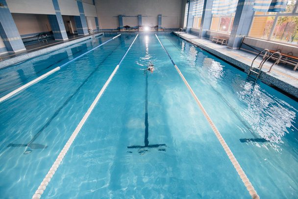 A young athlete trains and prepares for swimming competitions in the pool. Healthy lifestyle. - 写真・画像