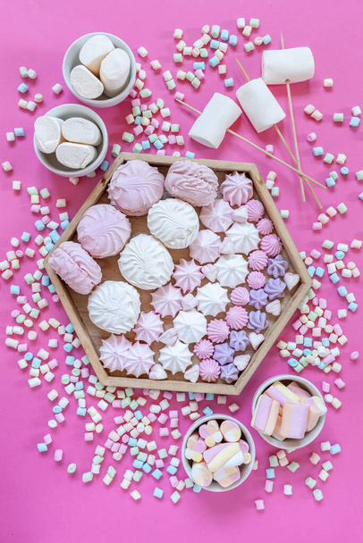 Meringue and variety Marshmallows charcuterie board on pink background. Close up, top view. - 写真・画像