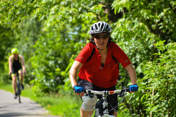 POLTAVA, UKRAINE - 19 kesäkuu, 2021: Pyöräilijät ajaa polkupyöriä puistossa kesällä iltapäivällä triathlon kilpailuissa - Valokuva, kuva